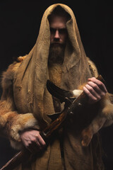 Portrait of a medieval bearded military monk, dressed in animal skins and burlap, holding a battle ax. Low key. Focus on your clothes. Atmospheric portrait of a character from a RPG game