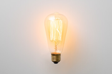 vintage light bulb glows without wires on white background