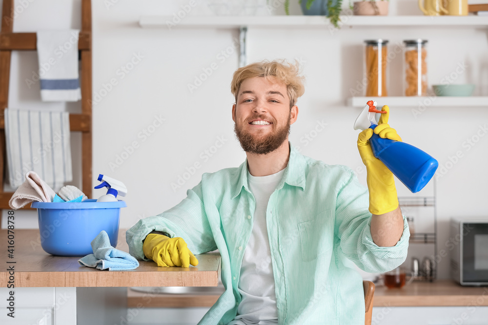 Young man cleaning his kitchen