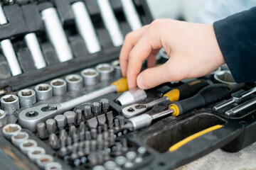 worker hand taking the tool from the set case to do make the project