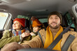 © pressmaster - Happy young active man in warm winterwear looking through front window of car