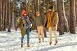 © pressmaster - Happy young parents in warm winterwear holding jumping little daughter by hands