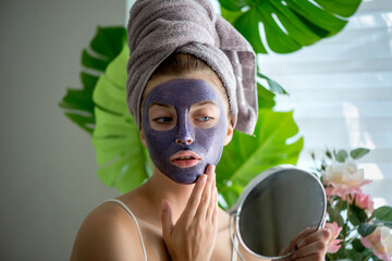 Wall Mural - Young woman with violet shiny glamor face mask on her face.