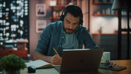 Aufkleber - Handsome Caucasian Man With Headphones Talk on Video Conference Call on Laptop while Sitting in Dark Living Room in the Evening. Student Studying in Home School. Chat with Friends on Social Network.