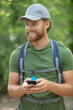 © auremar - young explorer bearded man trekking using mobile phone for gps