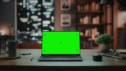 Poster - Laptop Computer with Mock Up Green Screen Display Standing on the Table in Cozy Living Room. In the Background Stylish Modern Home Office Studio in the Evening with Big Cityscape Window.