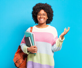 Wall Mural - young student afro woman feeling happy, surprised and cheerful, smiling with positive attitude, realizing a solution or idea