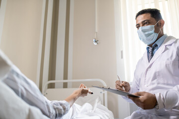Poster - Doctor in formalwear, whitecoat and protective mask listening to sick patient