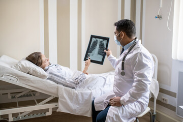 Poster - Young male radiologist and sick female patient discussing her lung x-ray image