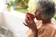 © Wavebreak Media - Thoughtful african american senior woman drinking coffee while sitting on porch of the house
