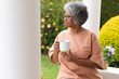 © Wavebreak Media - Thoughtful african american senior woman holding coffee cup while sitting on porch of the house
