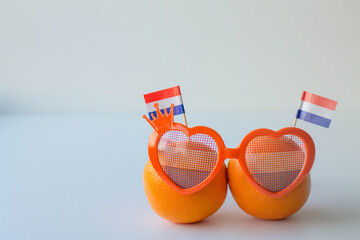 Oranges with Dutch flag and funny eye glasses on white background. Celebration of Dutch traditional king's day - Koningsdag. 27 april. Copy space 