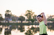 © EduLife Photos - Young beautiful Asian woman in sports outfits doing stretching before workout outdoor in the park in the morning to get a healthy lifestyle. Healthy young woman warming up outdoors.