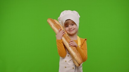 Wall Mural - Child girl kid dressed as professional cook chef baker showing and sniffing two fresh baguettes, smiling, waving head in agreement on chroma key background. Nutrition, cooking school, education, food