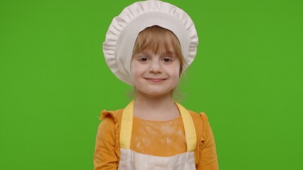 Joyful caucasian teen child girl kid dressed as cook chef baker in apron smiling, fooling around, making silly funny faces, showing tongue. Isolated on chroma key background. Copy-space. Restaurant