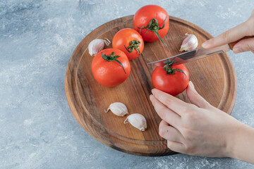 Fresh tomatoes with garlic on a wooden board