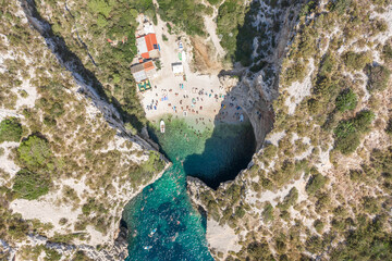 Wall Mural - Aerial overhead drone shot of tourists swim sunbath at Stiniva beach on Vis Island in Croatia summer