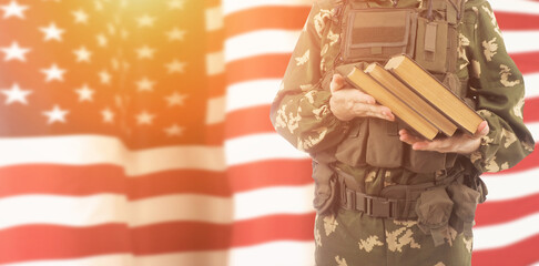 Cadet of military school with books on USA flag background .