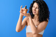© Pixel-Shot - Beautiful young woman with cosmetic product on color background