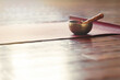 A singing bowl stands on a yoga mat on a wooden floor with copy space. Sound therapy and relaxation concept.
