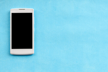 Smartphone top view on a blue background. Copy space