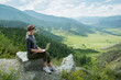 © Sergey - Beautiful woman hipster traveler freelancer with laptop  on the top of the mountain. Remote work concept.
