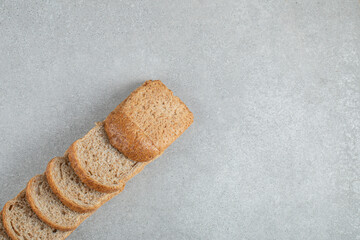 Wall Mural - Slices of fresh brown bread on a gray background