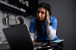 © Zoran Zeremski - Tired young female nurse at home in the kitchen having video call using laptop.