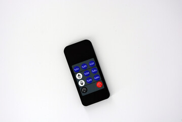 Black plastic radio remote control on batteries with colored buttons located on a white plastic background.