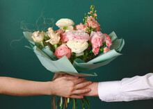 Man Holding And Giving A Beautiful Bouquet With Flowers To Woman On Green Background. Front View. Valentine's, Women's, Mother's Day, Love Concept.