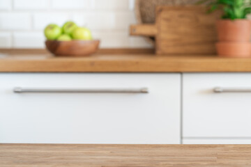 Kitchen table against the background of blurred modern home light kitchen. Empty oak wood table top