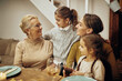 © Drazen - Happy female members of extended family talking in dining room.