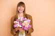 © deagreez - Photo of dreamy nice happy cheerful lady look empty space hold flowers isolated on pastel beige color background