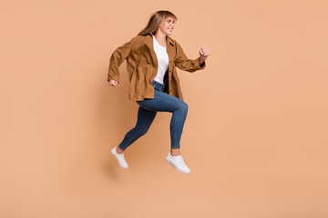 Wall Mural - Full body profile side photo of young charming lady jump up run sale empty space isolated on beige color background