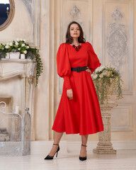 elegant tall slim beautiful caucasian woman with long brunette hair and natural make-up wearing red 