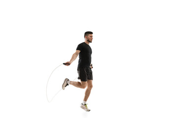 Jumping. Caucasian professional sportsman training isolated on white studio background. Muscular, sportive man practicing. Copyspace. Concept of action, motion, youth, healthy lifestyle.