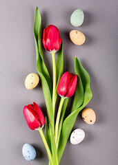 Wall Mural - Pink tulips and quail eggs over gray background, Easter. Birthday, mother day greeting card concept with copy space. Top view, flat lay.