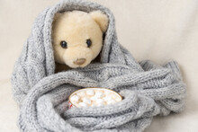 A White Teddy Bear Is Wrapped In Scarf, Next To Cup Of Hot Chocolate With Marshmallows In The Garland Lights