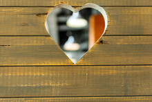 A Heart-shaped Hole Has Been Carved Into The Wall Of The Boards. Lamps Are Visible Through The Hole. The Door To The Cafe