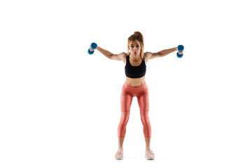 Dumbbells. Young caucasian female model in action, motion isolated on white background with copyspace. Concept of sport, movement, energy and dynamic, healthy lifestyle. Training, practicing.