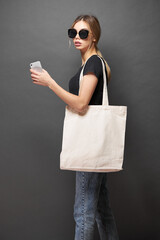 Wall Mural - Tote eco bag for mockup is held by a woman over gray texture