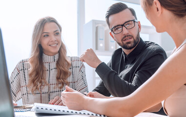 Poster - young business woman explaining her ideas at a business meeting.