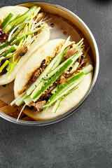 Canvas Print - Bao bun with roast duck. Bamboo steamer on dark slate table. Chinese, asian, authentic food concept