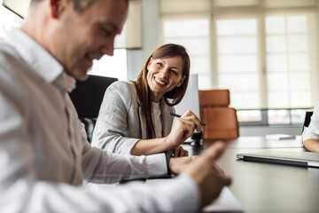 Preparing himself for interview, smiling woman sitting next to him.