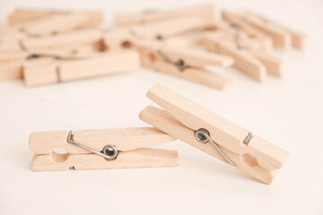 Many wooden clothespins on a white table background. Housework concept. Copy, empty space for text