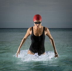 Wall Mural - Sporty woman running on dark water background