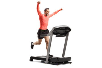 Poster - Full length shot of a young man running on a treadmill and gesturing happiness