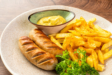 Wall Mural - German fried sausages with French fries and mustard sauce. 
