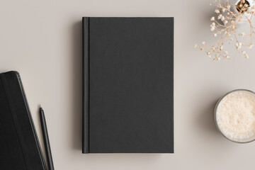 Wall Mural - Black book mockup with a gypsophila, coffee and workspace accessories on the beige table.