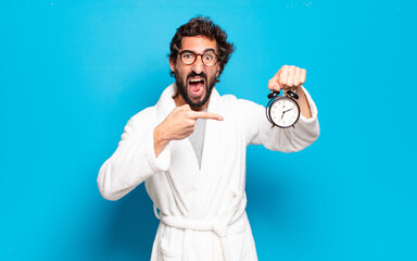 Wall Mural - young bearded man wearing bathrobe and an alarm clock